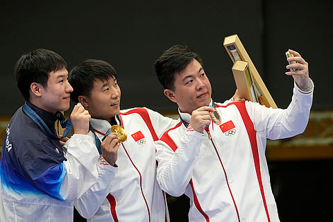 Men's 25m rapid fire pistol: Bronze medalist China's Wang Xinjie, right, take a selfie with gold medalist and fellow countryman Li Yuehong, center, and silver medalist South Korea's Cho Yeong-jae